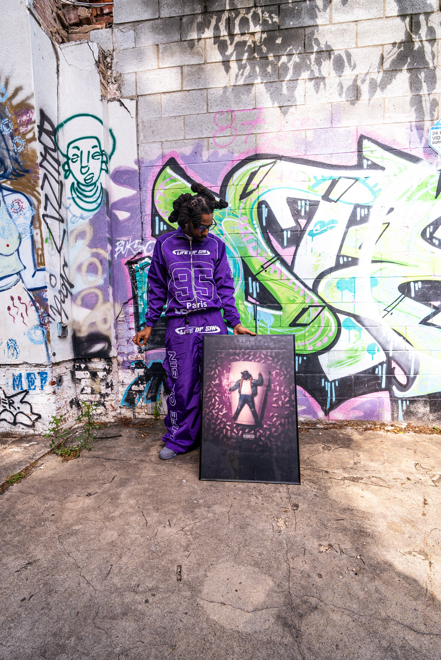 Portrait beside graffiti and framed artwork