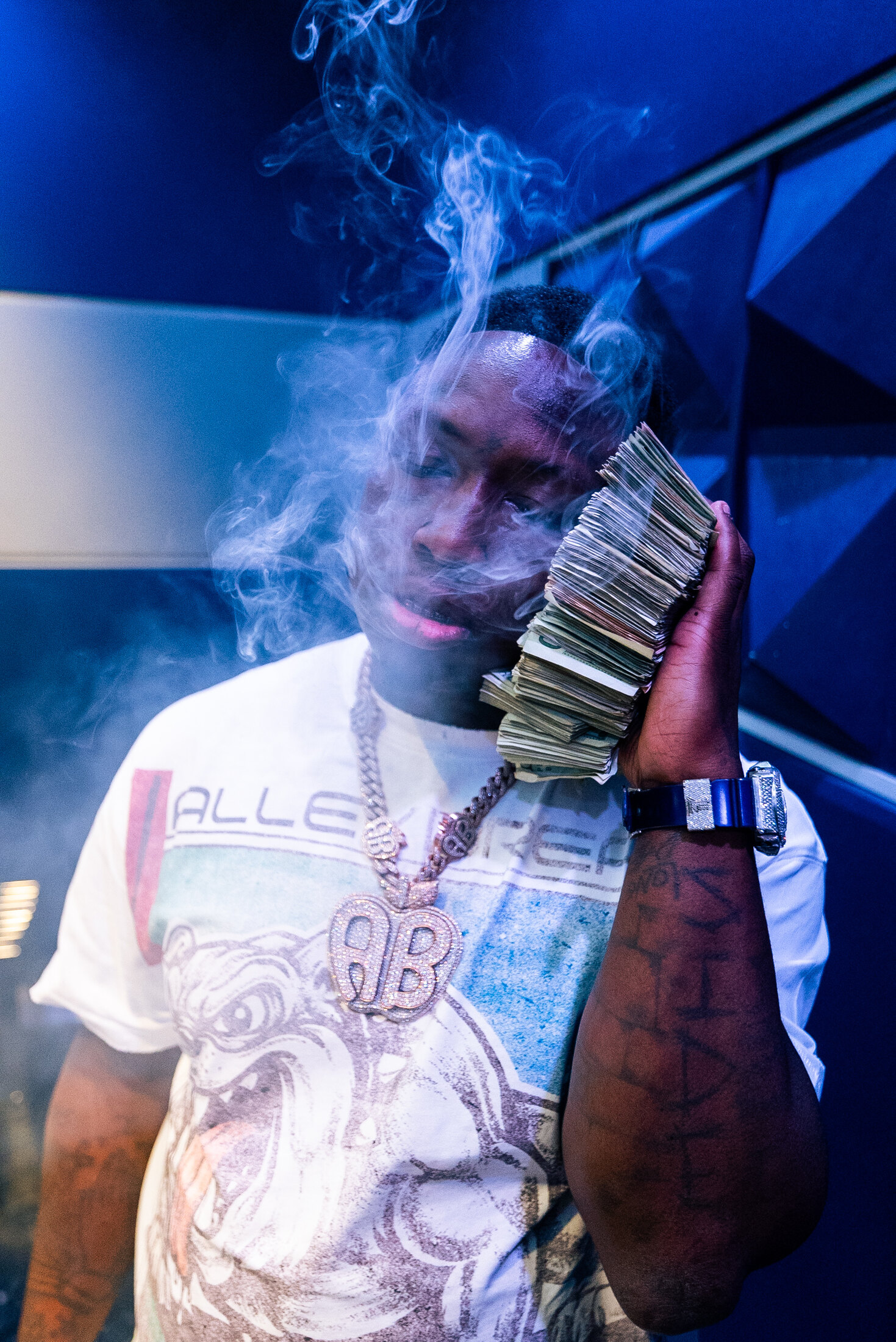 Blue-lit portrait with smoke and money