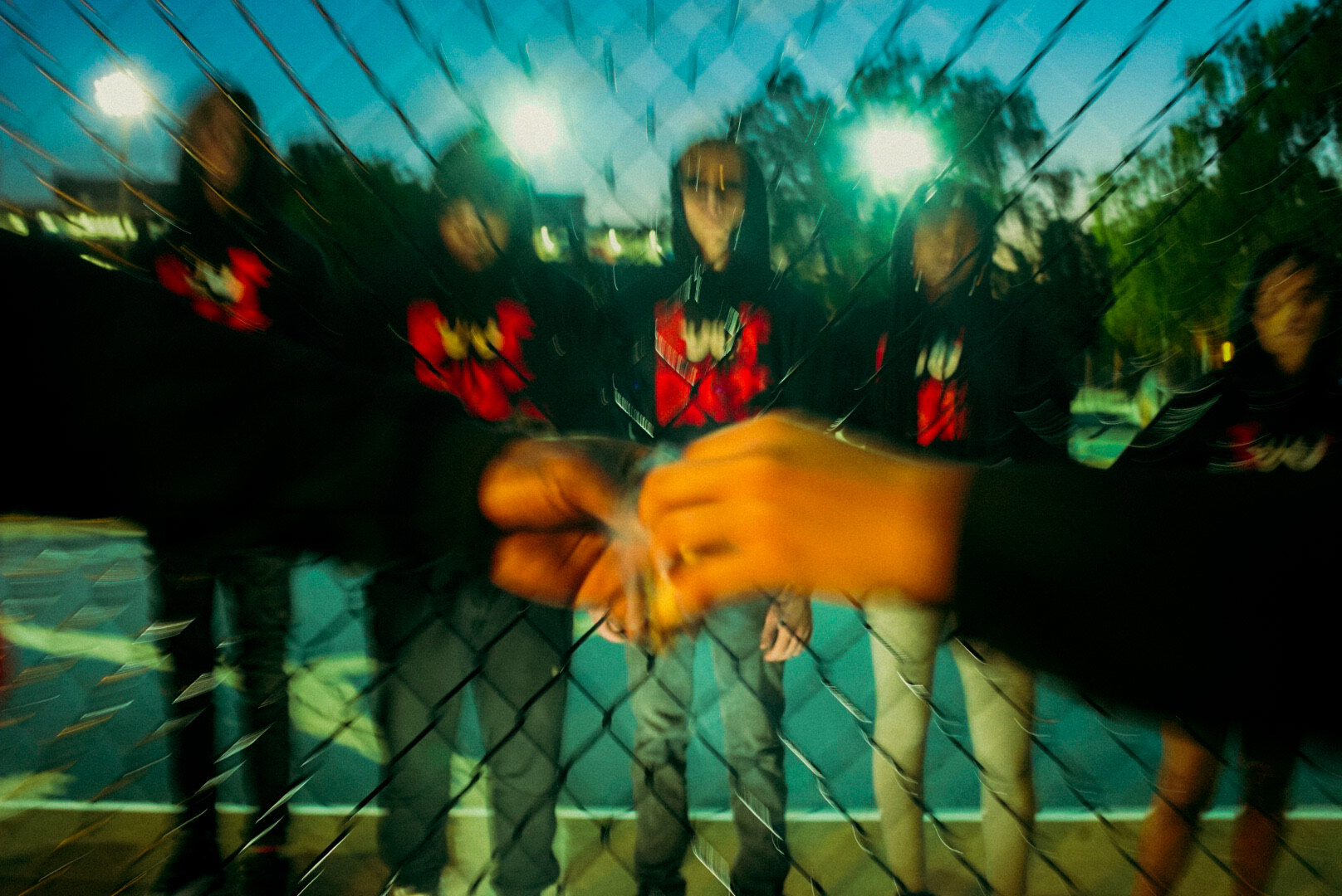 Double-exposure portrait behind a fence